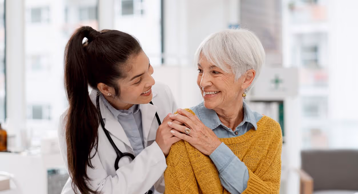 A care provider embraces a smiling patient