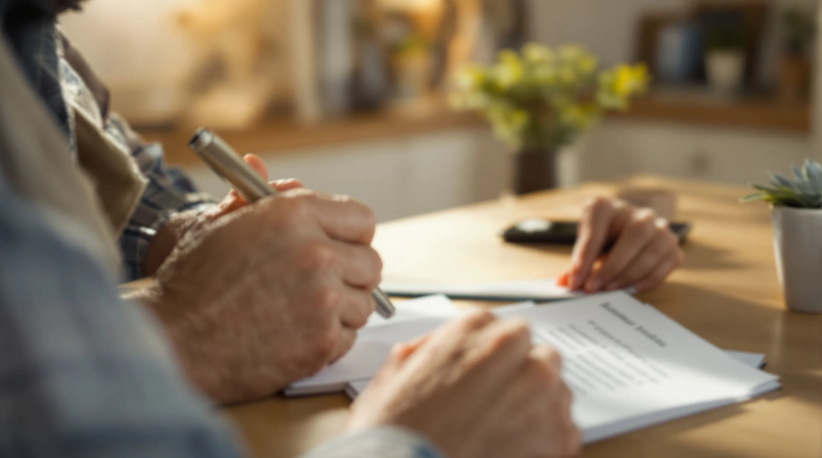 An older adult reviews a notepad of questions while on a phone call about choosing a patient advocate.